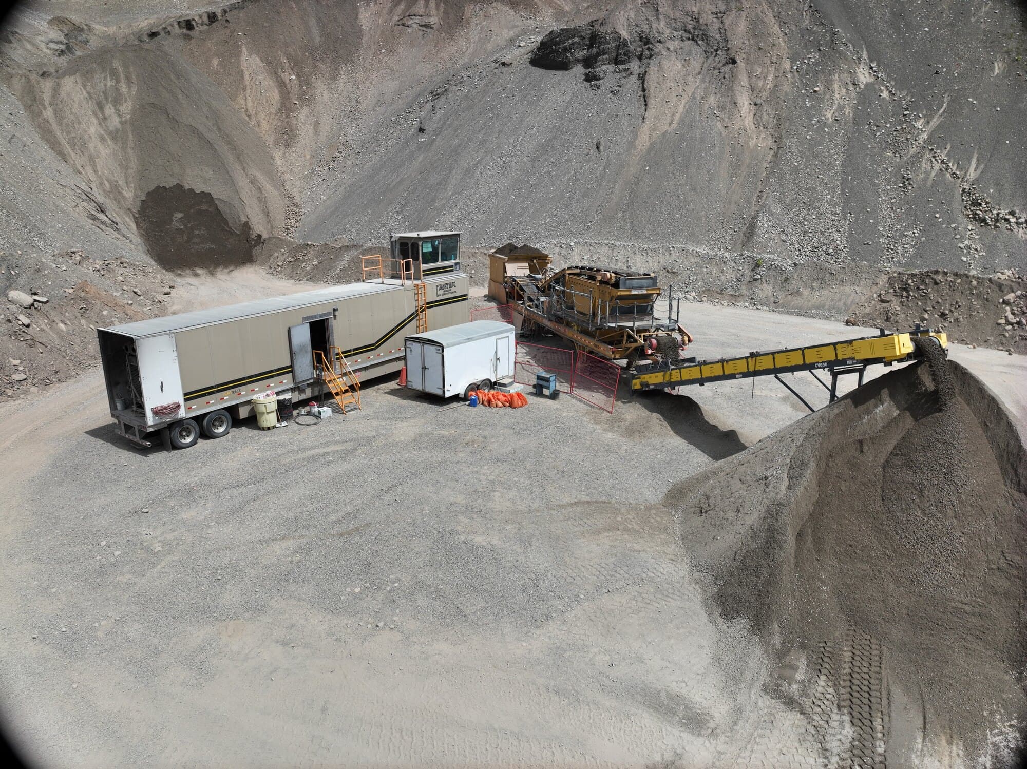 A Cantex screening setup and site trailers on a cleared pad deep inside a steep rock pit, seen from the air.