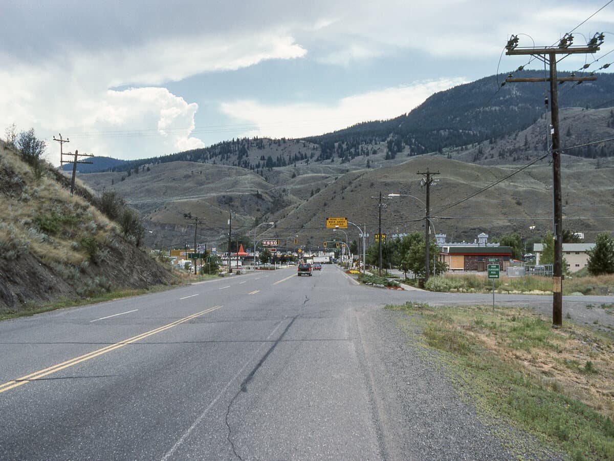 The Trans-Canada Highway running through the village of Cache Creek, with the dry Thompson-Nicola hills on either side.