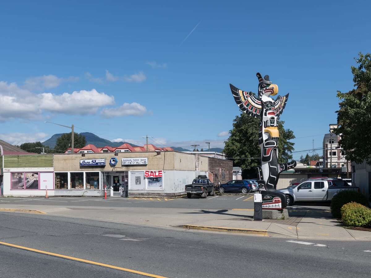 Government Street in downtown Duncan, the "City of Totems", with a totem pole and the Cowichan Valley hills behind.