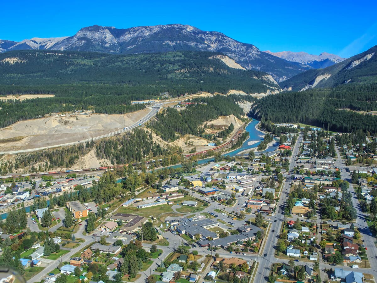 Aerial view of the town of Golden in the Columbia Valley, with the Kicking Horse River and the Rocky Mountains behind.