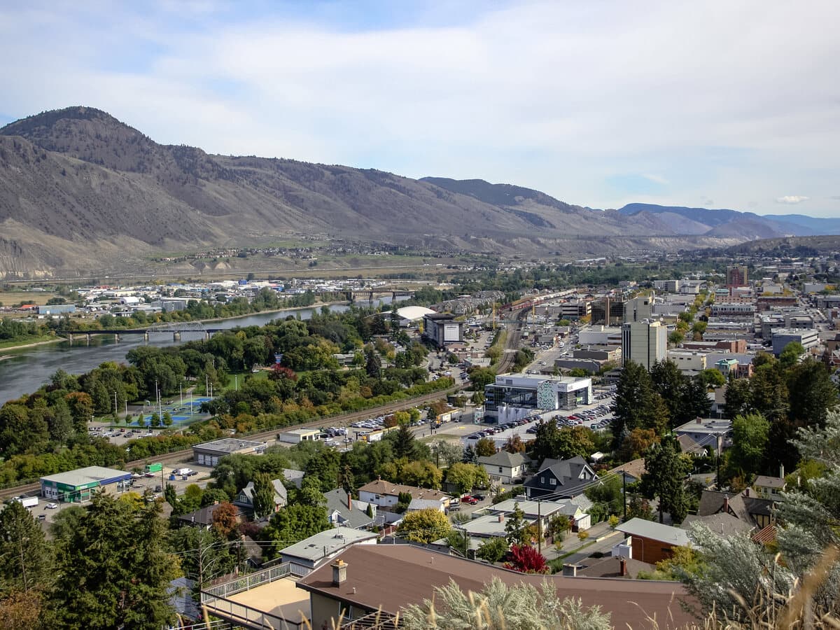 The city of Kamloops in the Thompson River valley, seen from the hills above with the downtown core and river below.