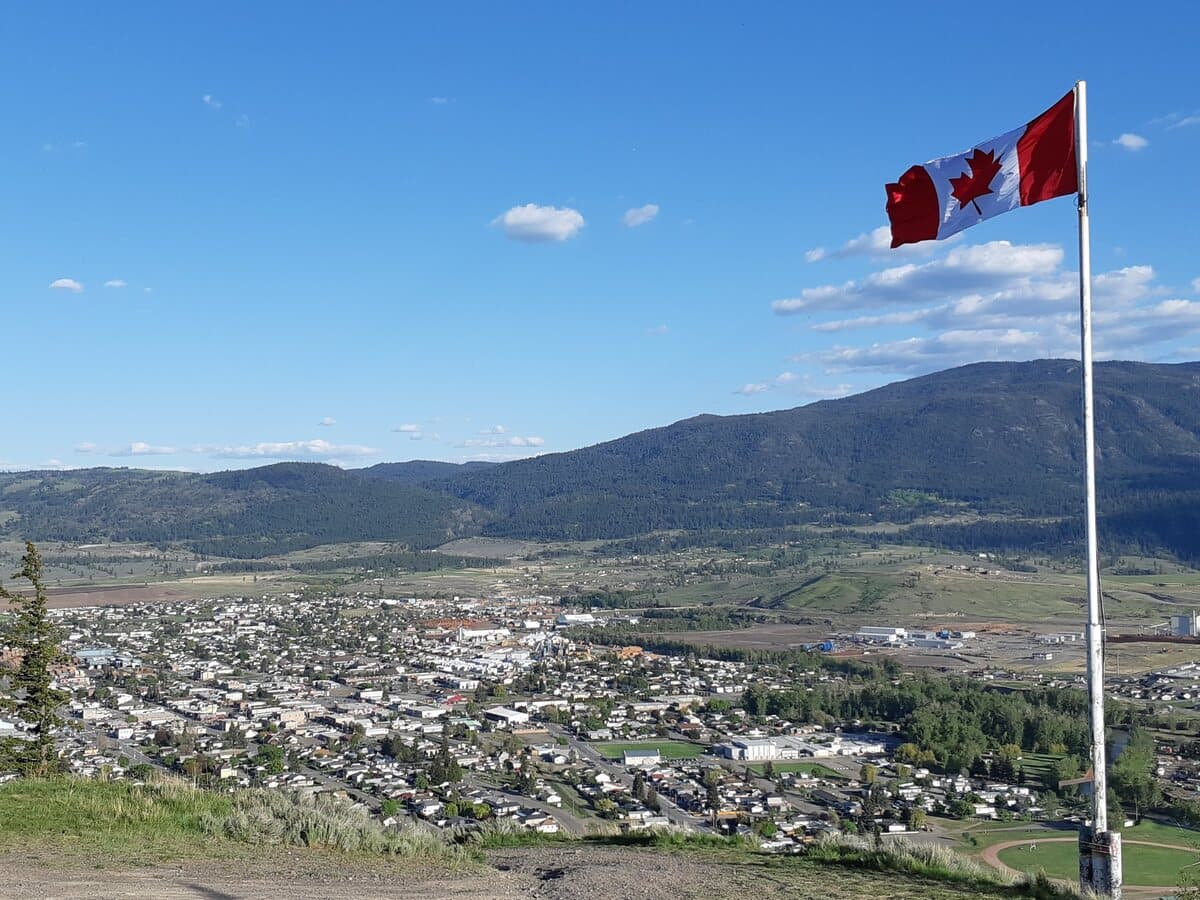 A hillside lookout over the town of Merritt in the Nicola Valley, with a Canadian flag in the foreground.