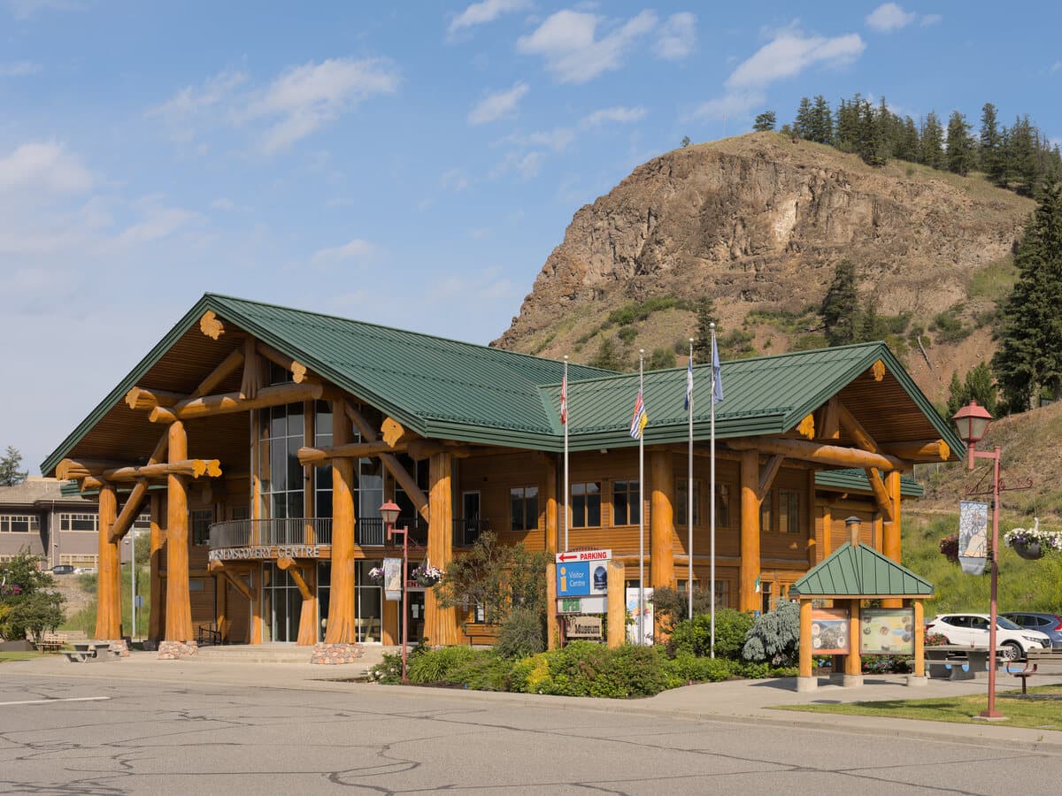 The timber-framed Tourism Discovery Centre in Williams Lake, with the Cariboo bluffs rising behind it.